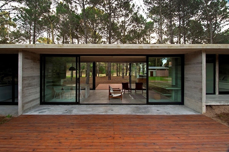 Дом из стекла и бетона в окружении деревьев